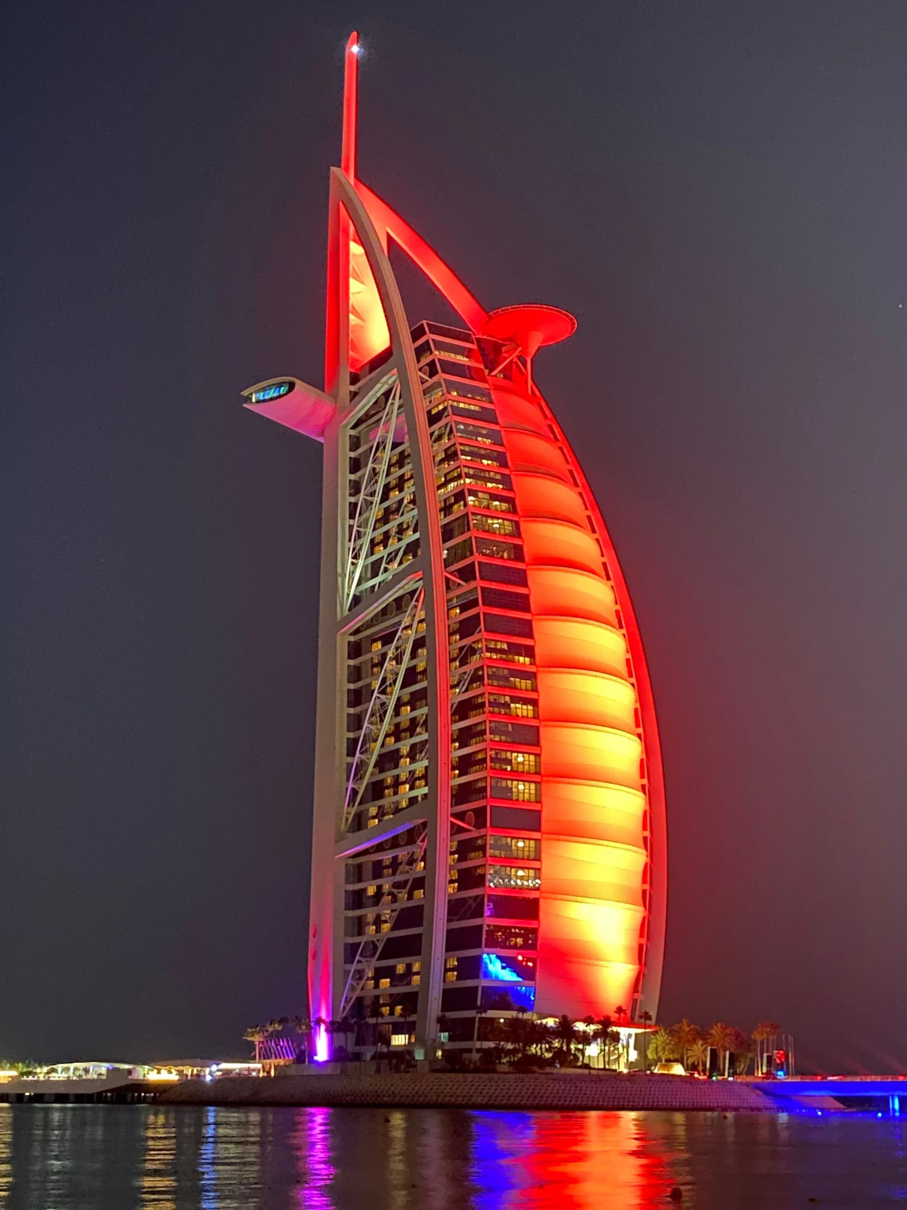 Burj Al Arab illuminated beside the Dubai coast at night