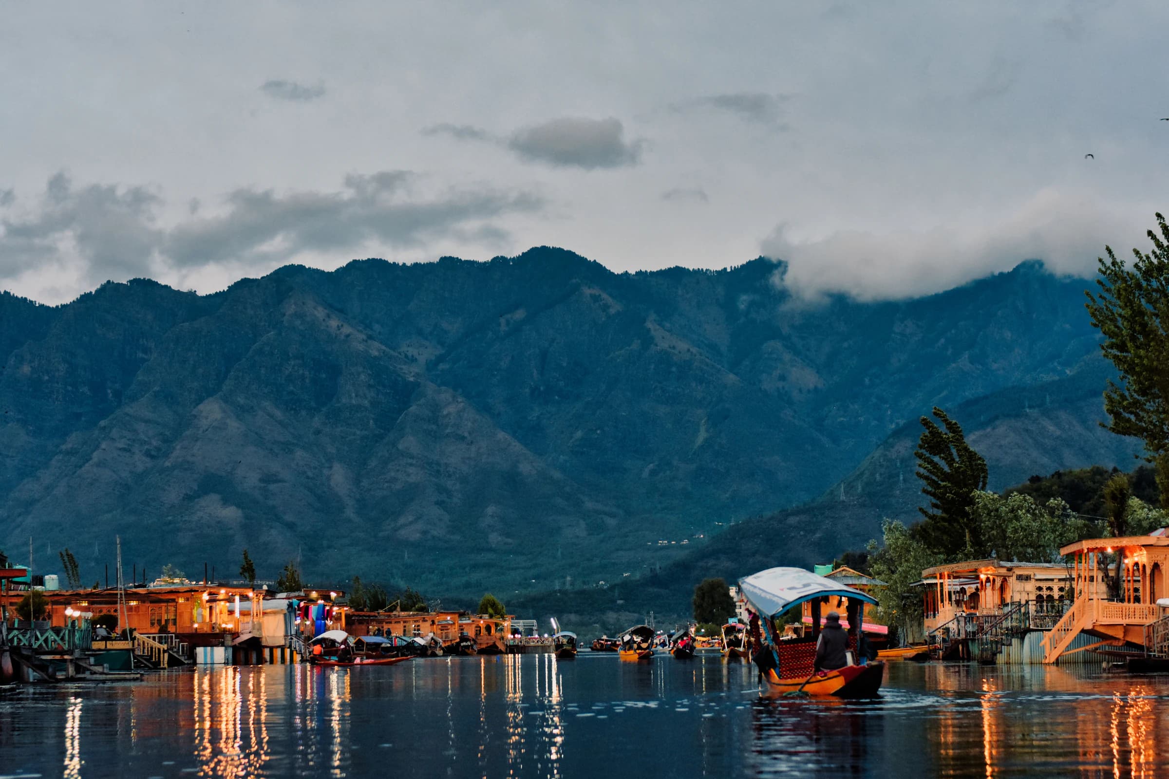 Traditional boats on Dal Lake beneath the mountains
