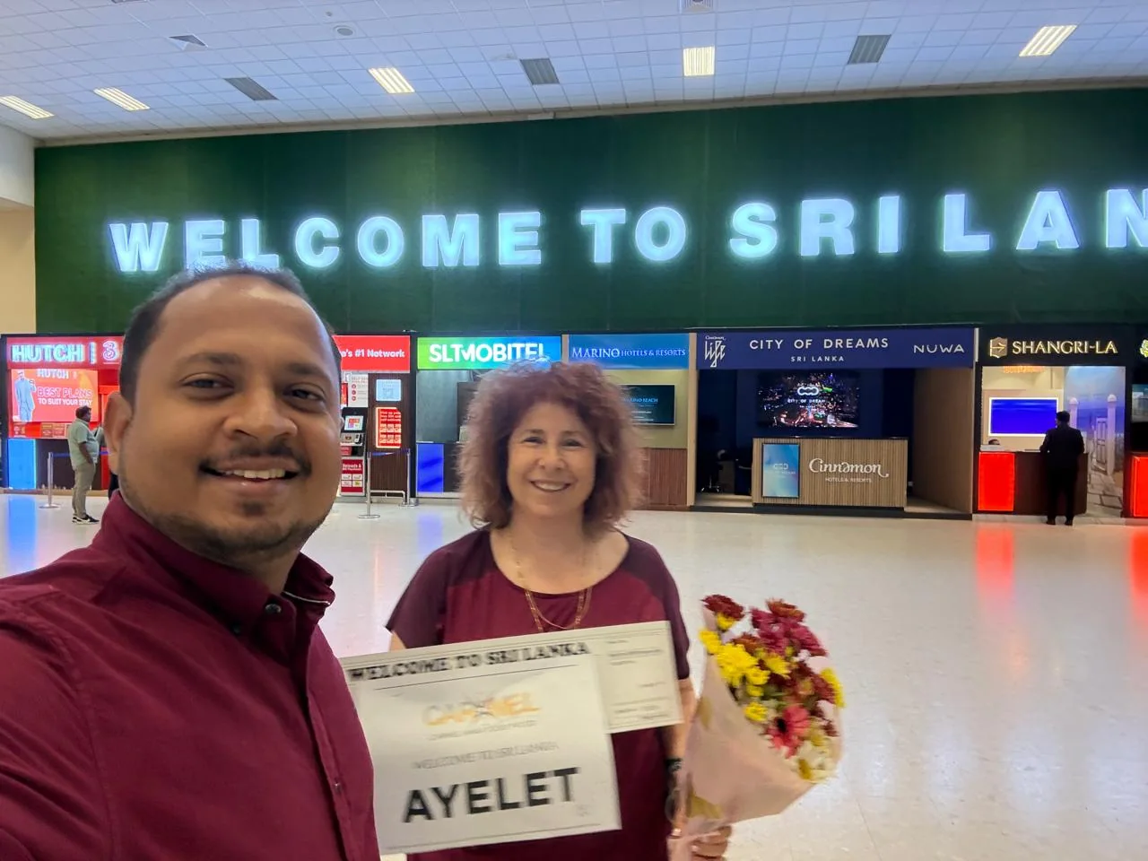 Guest arriving in Sri Lanka with a welcome board and flowers